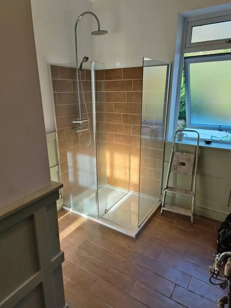 Bathroom fitting Enfield period-style shower enclosure with wood-effect tiles and chrome rainfall head - Resale Refurbs Ltd