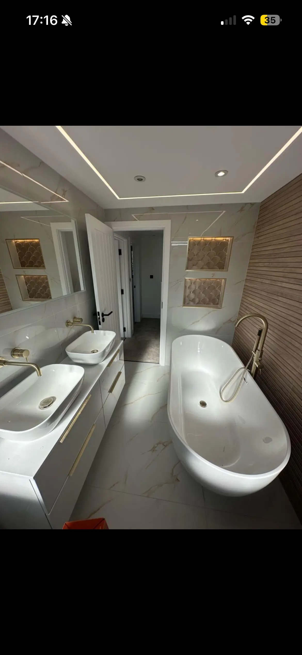 Luxury bathroom fitting London — freestanding bath with marble tiles and gold fixtures — Resale Refurbs Ltd