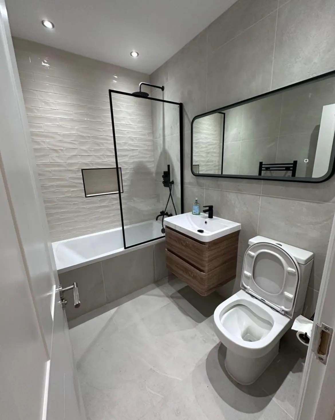 Bathroom installation London — black frame shower screen and wooden vanity — Resale Refurbs Ltd