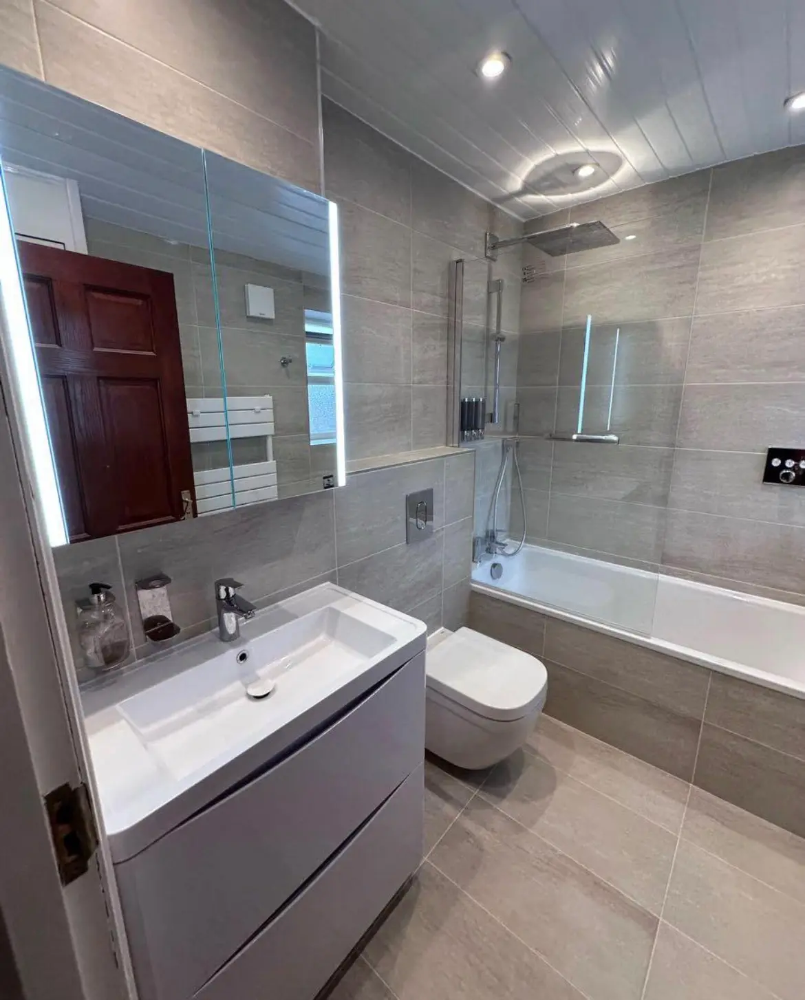 Bathroom refurbishment London — grey large format tiles with LED mirror — Resale Refurbs Ltd