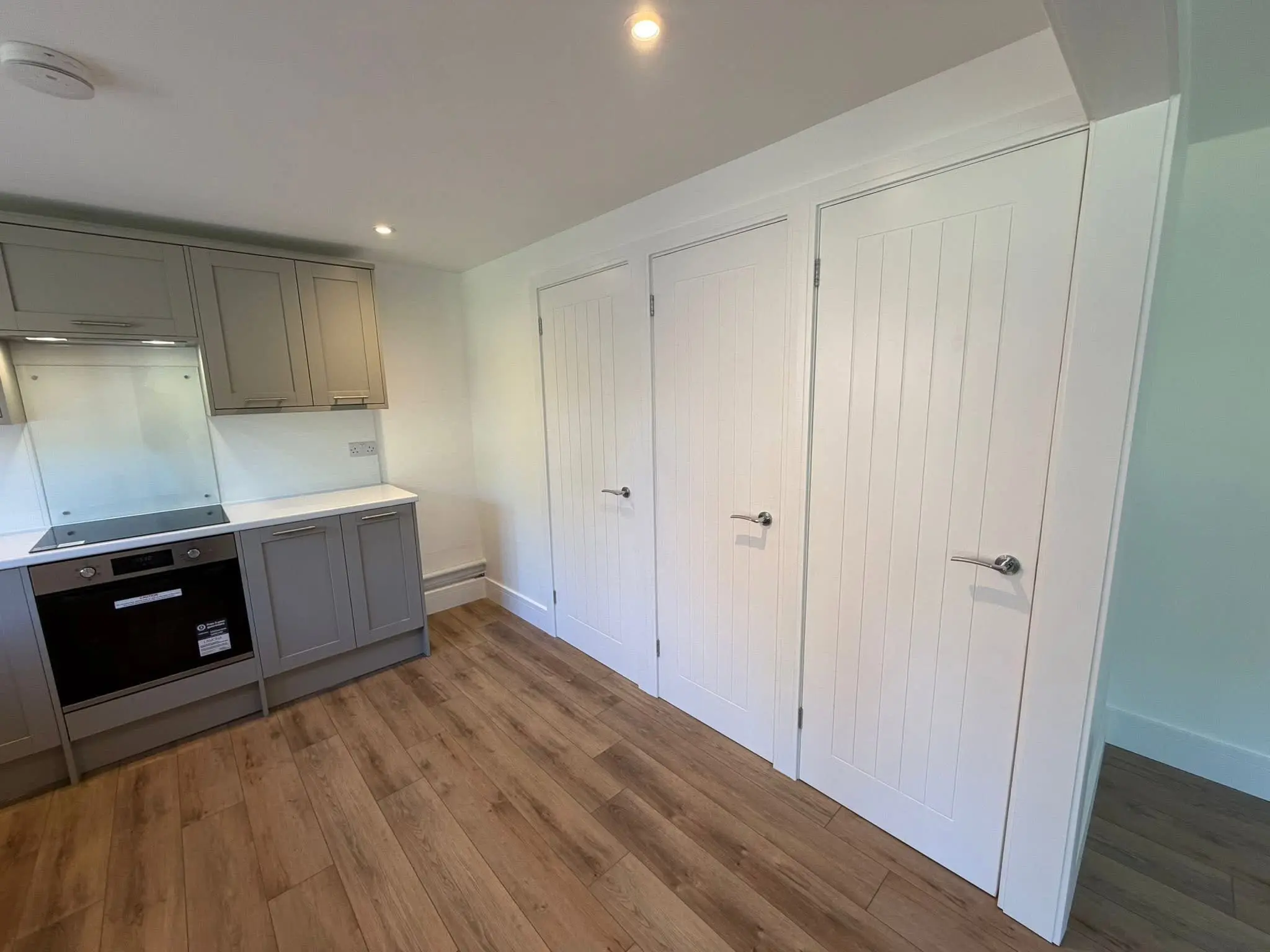 Kitchen installers Barnet - grey shaker kitchen with glass splashback and new flooring