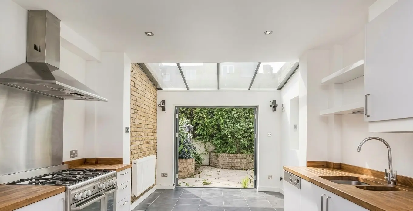 White kitchen renovation Barnet London with oak worktops and glass roof extension — Resale Refurbs Ltd